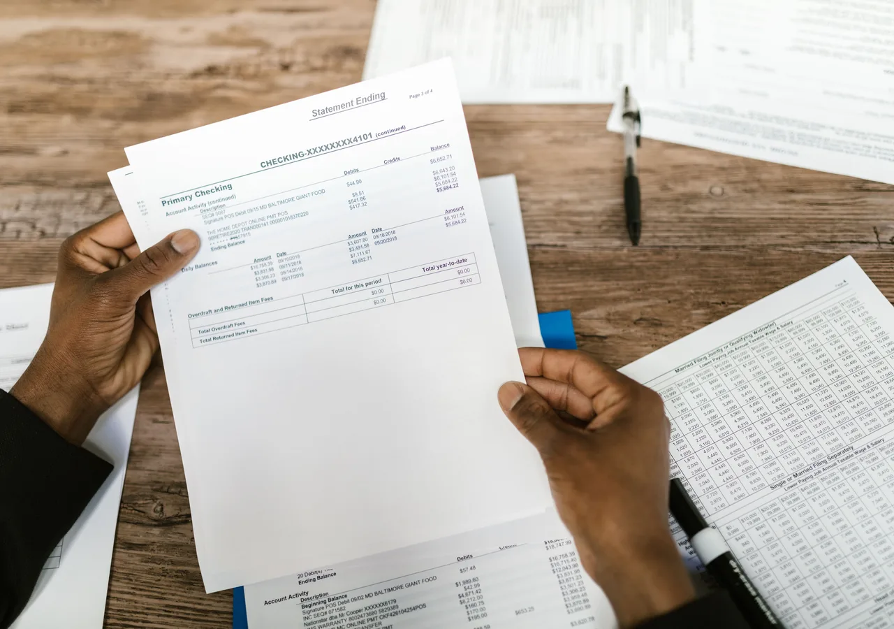 Magnifying glass examining transaction terms and compliance documents