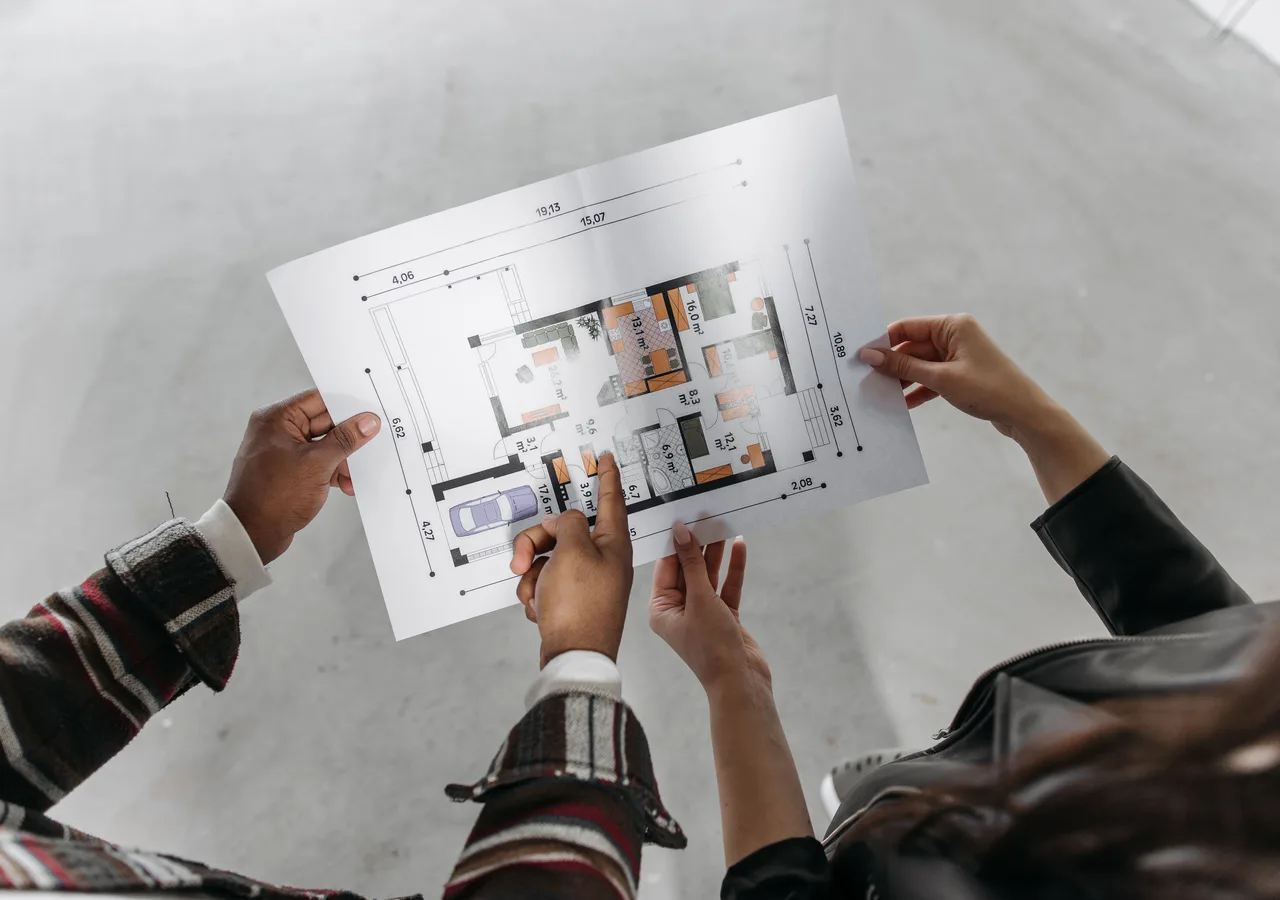 Hard hat, property keys and construction plans arranged for review